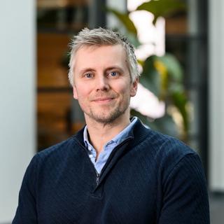 a man in a blue sweater and a black shirt